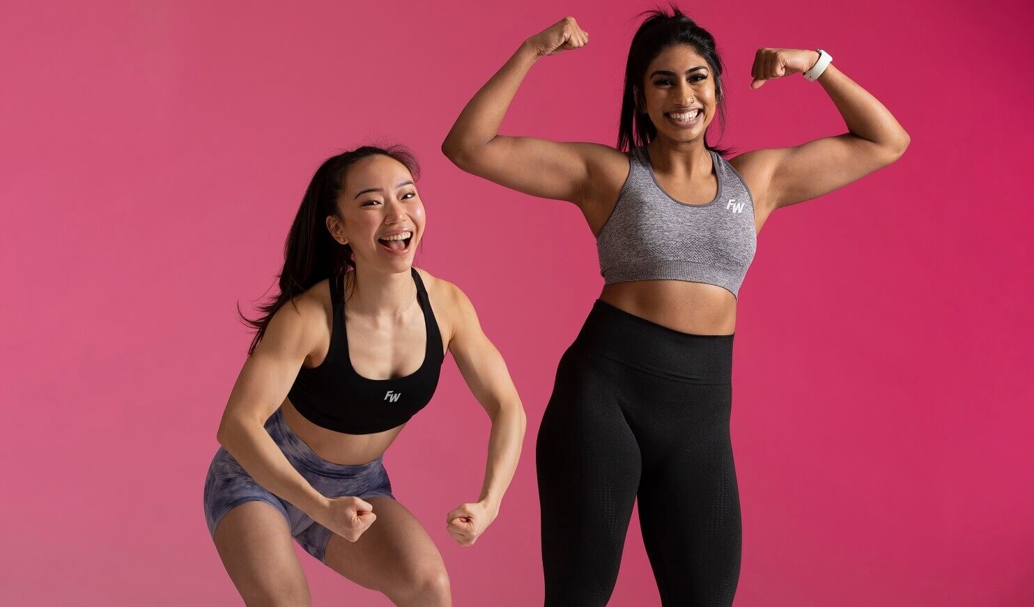 two woman flexing with pink background