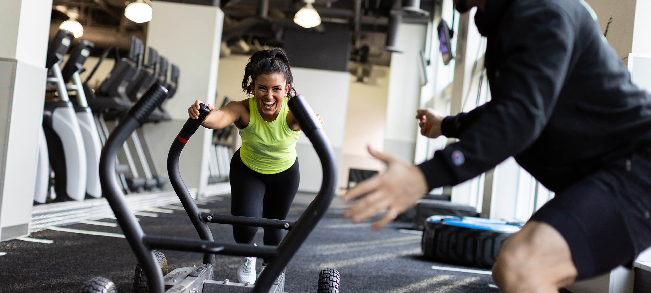 woman pushing a sled with instructor