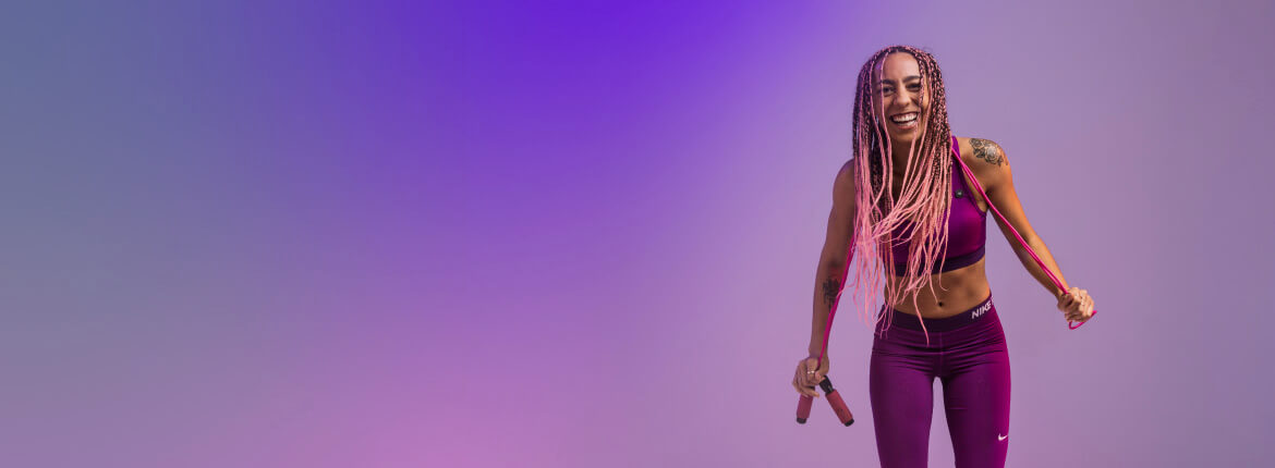 Girl wearing all purple fitness outfit with a jump rope