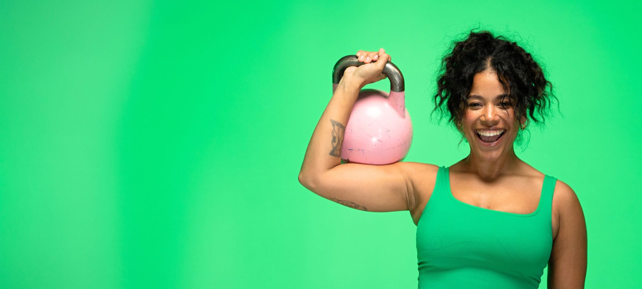 girl smiling holding a kettlebell